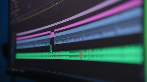 Timeline colorée d’un logiciel de montage vidéo affichée sur un écran