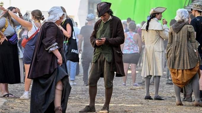 Figurants en costumes historiques sur un plateau de tournage