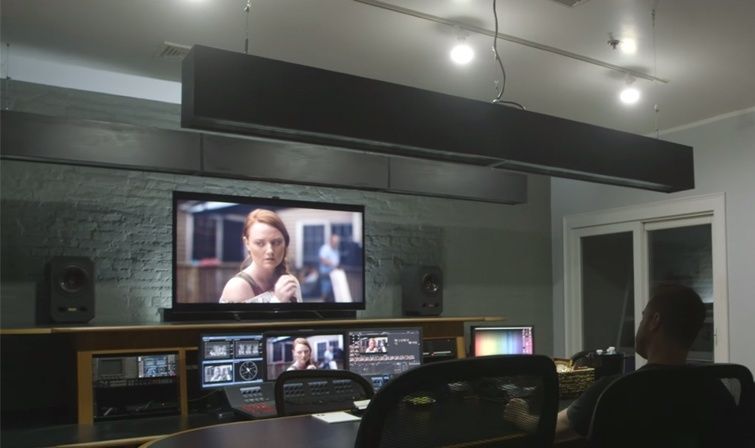 Salle d’étalonnage avec écrans affichant une scène de film