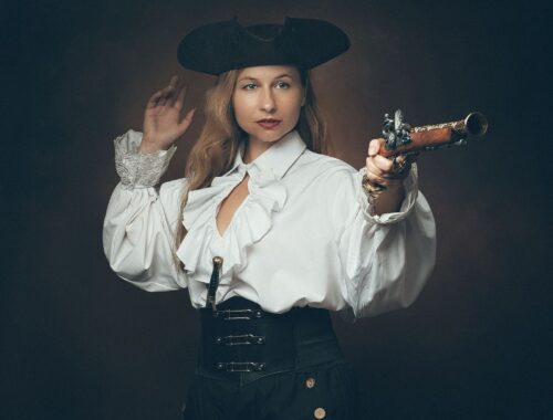 Femme en costume historique, tricorne noir et pistolet à la main