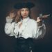 Femme en costume historique, tricorne noir et pistolet à la main